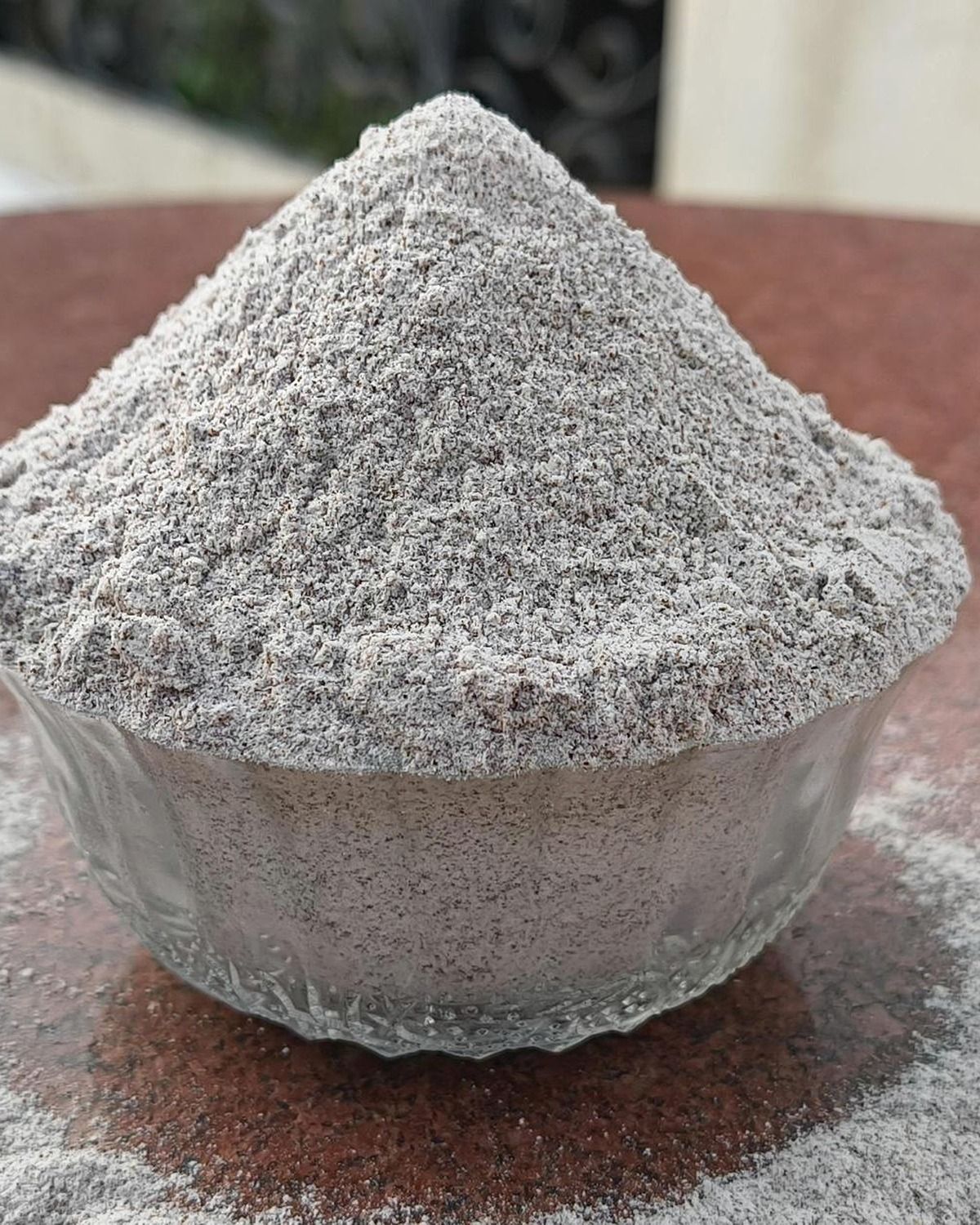 Real hands inspecting fine whole finger millet flour